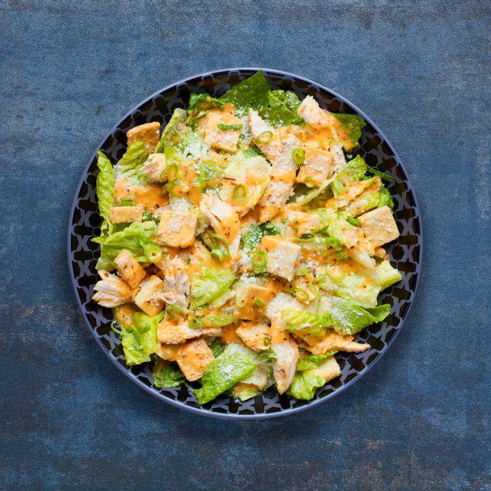 Nando's Chicken Caesar Salad on a blue background